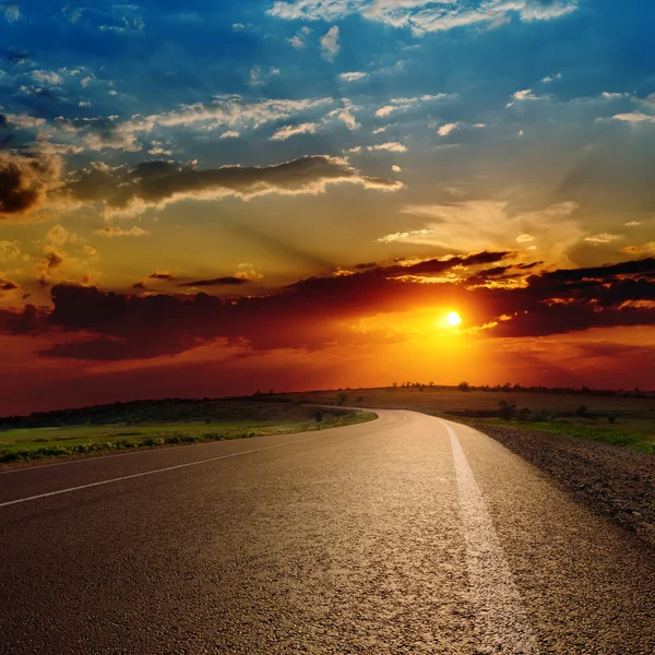 Asfalt yol üzerinde dramatik kırmızı günbatımı — Stok fotoğraf