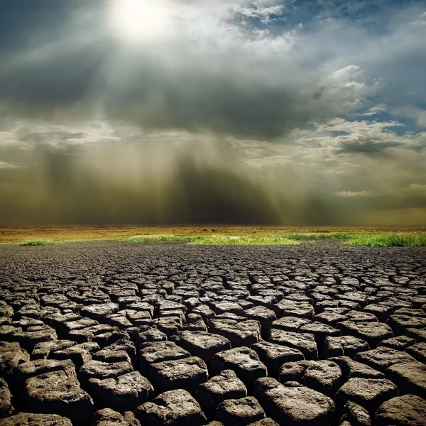 Dramatic sky with sun over drought earth Royalty Free Stock Images