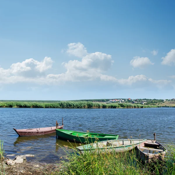 River and old boats near green grass under cloudy sky — Stock Photo, Image