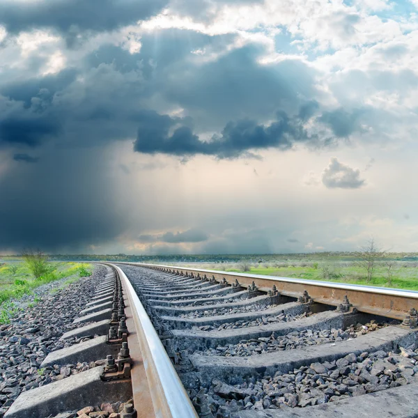 Järnvägen till horisonten under dramatisk himmel — Stockfoto