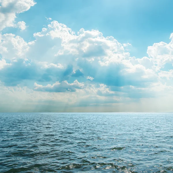 Mar azul e céu nublado sobre ele — Fotografia de Stock