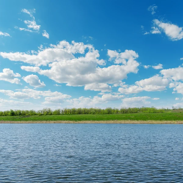 Nuvole sul fiume con costa verde — Foto Stock