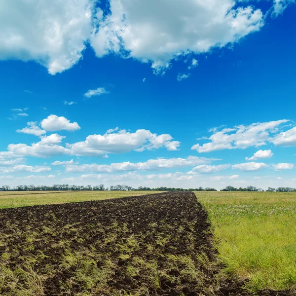 Céu azul nublado e campo arado — Fotografia de Stock