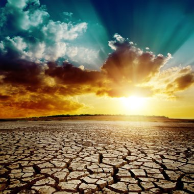 global warming. dramatic sunset over cracked earth clipart