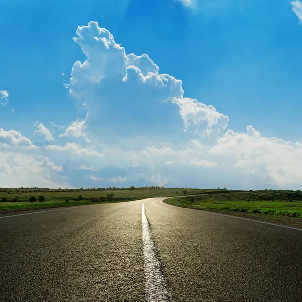 Closeup de estrada de asfalto sob céu azul nublado — Fotografia de Stock