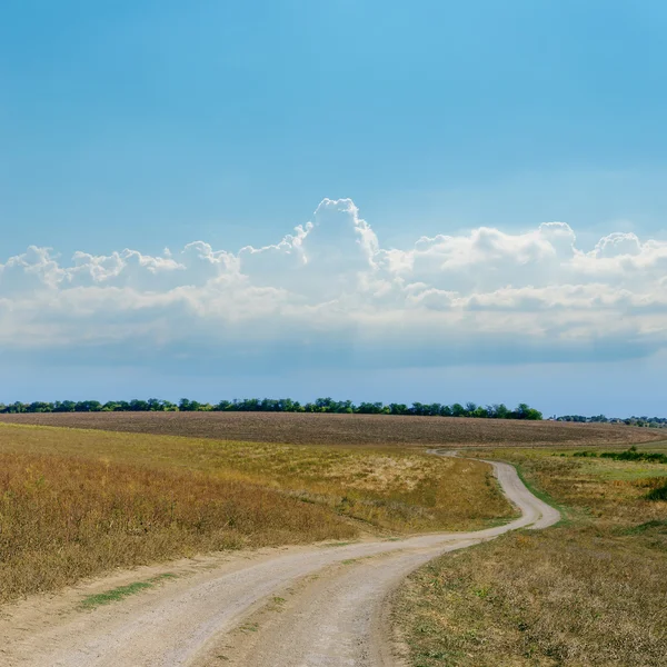 Estrada suja e céu nublado azul — Fotografia de Stock