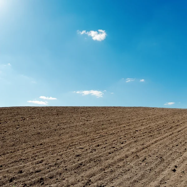 Blue sky and black agriculture field — Stock Photo, Image