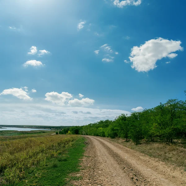 Estrada rural vai para o horizonte sob céu nublado — Fotografia de Stock