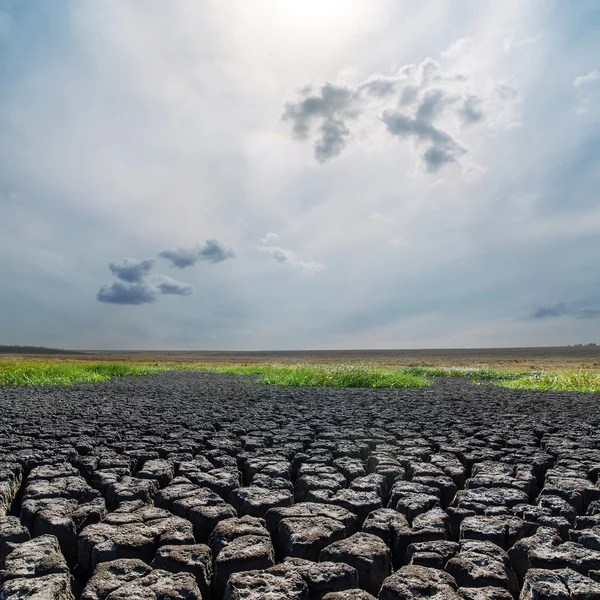 Calentamiento global. cielo dramático sobre tierra agrietada — Foto de Stock