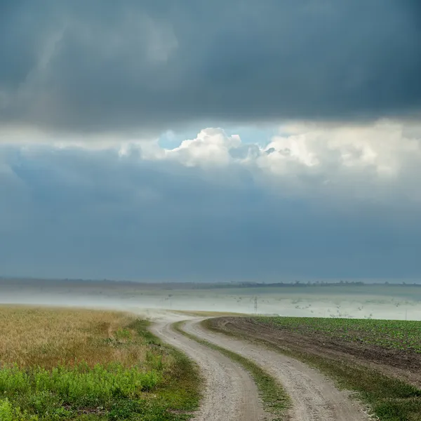 Dirt road with dust under dark clouds. rain before — Stock Photo, Image