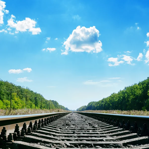 Spoorweg dicht tot horizon en bewolkte hemel — Stockfoto