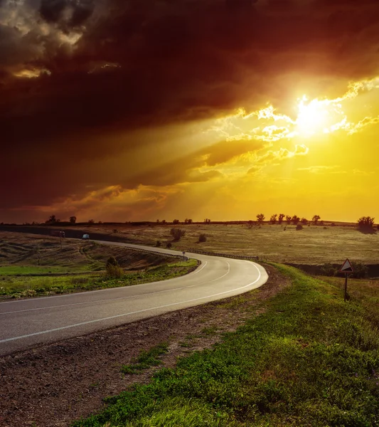 Laranja dramático pôr do sol sobre a estrada de asfalto — Fotografia de Stock