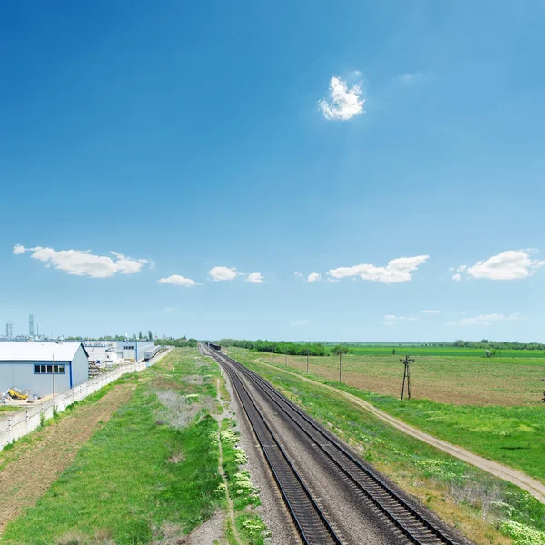 Järnvägen i gröna fält och blå himmel — Stockfoto