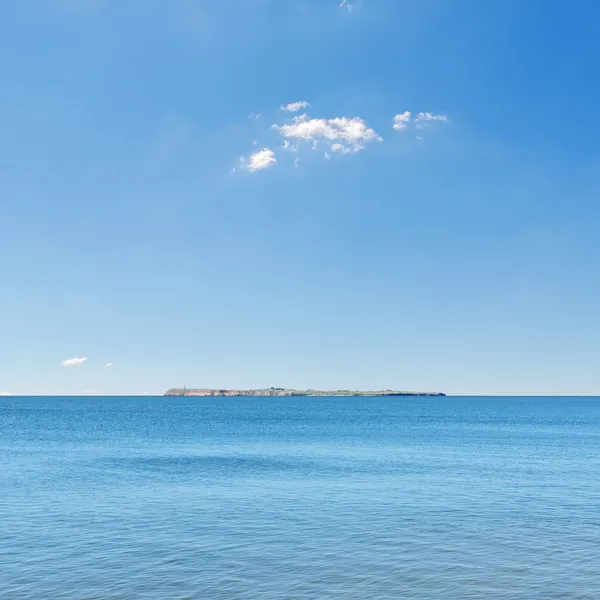Mar azul y cielo, isla en el horizonte —  Fotos de Stock