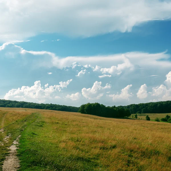 Nuvens sobre colina com grama — Fotografia de Stock