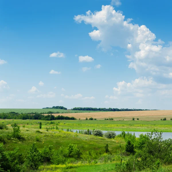 Grönt landskap med flod under blå molnig himmel — Stockfoto