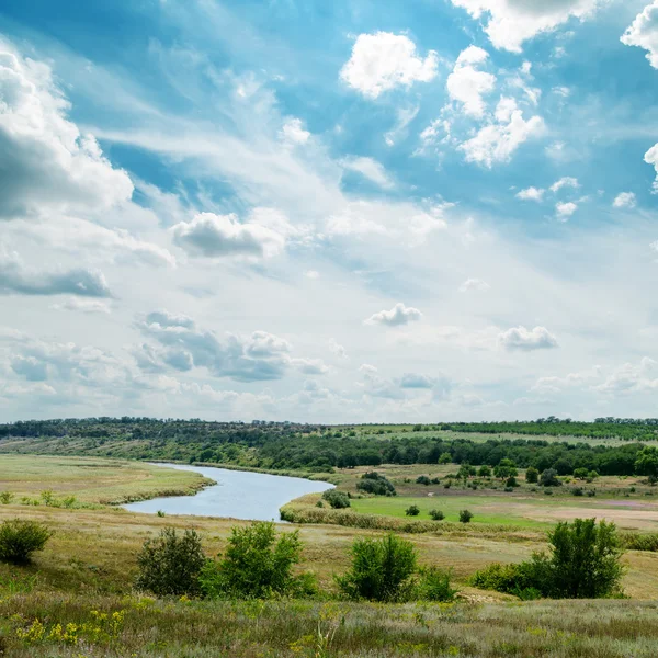 Zielony krajobraz z rzeką i pochmurne niebo — Zdjęcie stockowe