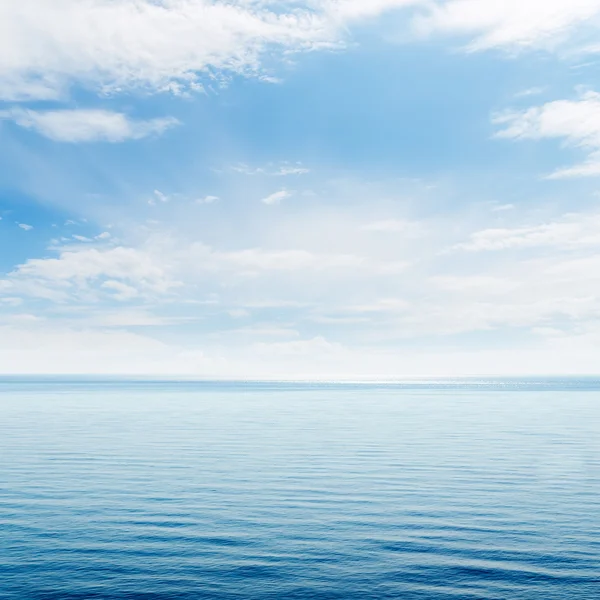 Blauwe zee en wolken in de lucht — Stockfoto
