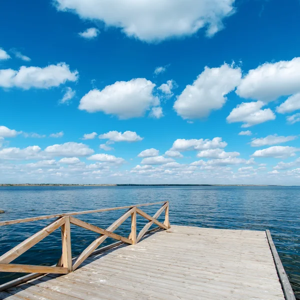 Piso de madeira sobre o rio e céu azul profundo — Fotografia de Stock