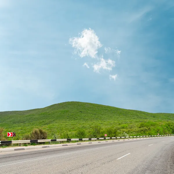 Estrada de asfalto em montanha sob luz nuvens no horizonte — Fotografia de Stock