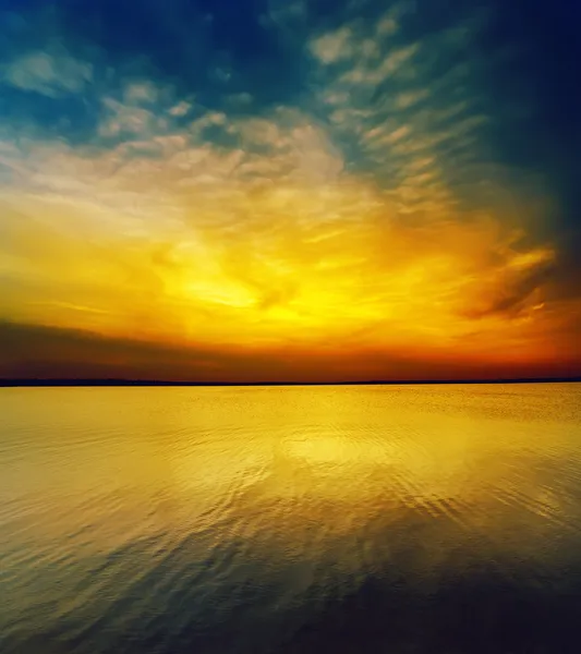 Karanlık su üzerinde fantastik günbatımı — Stok fotoğraf