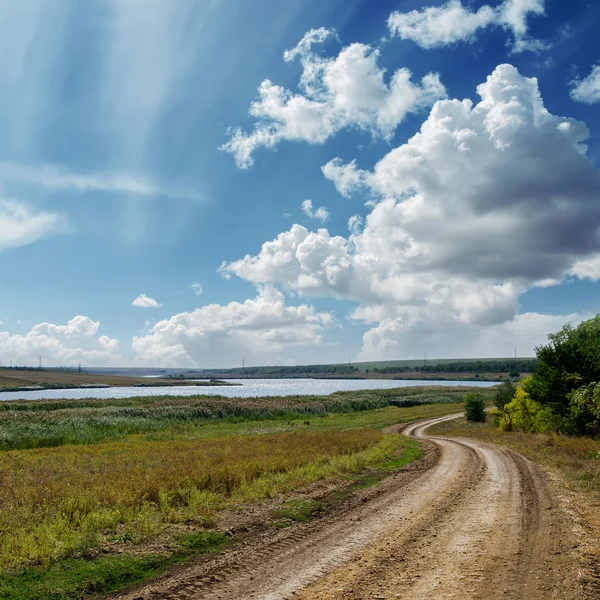 Sinuoso estrada país e nuvens no céu azul — Fotografia de Stock