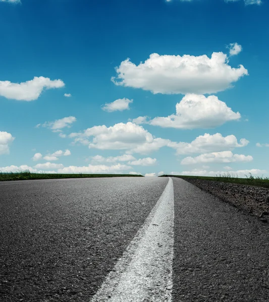 Asfalt yol mavi bulutlu gökyüzü altında — Stok fotoğraf