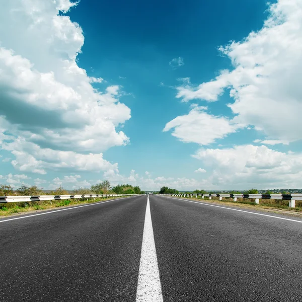 White line on asphalt road and clouds over it — Stock Photo, Image