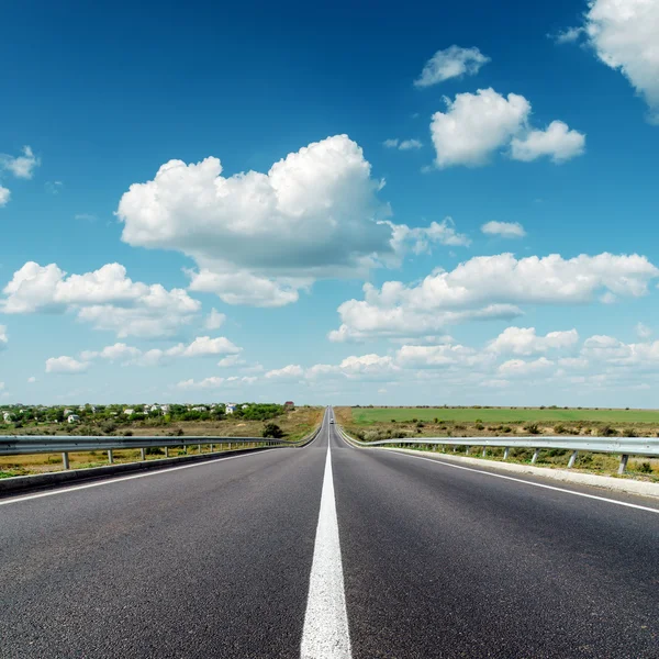 Estrada de asfalto para horizonte sob céu nublado — Fotografia de Stock