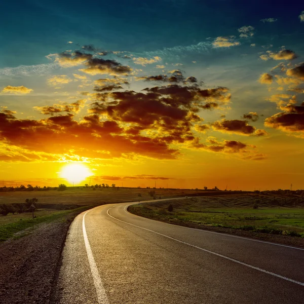 Lage oranje zon over asfaltweg — Stockfoto