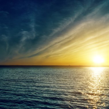 Sunset su üzerinde bulutlar ile