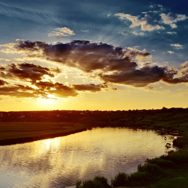 Pôr do sol nublado sobre o rio — Fotografia de Stock