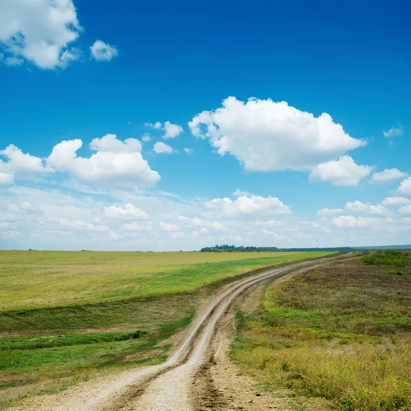 Dirty road and blue sky with clouds — Stock Photo, Image