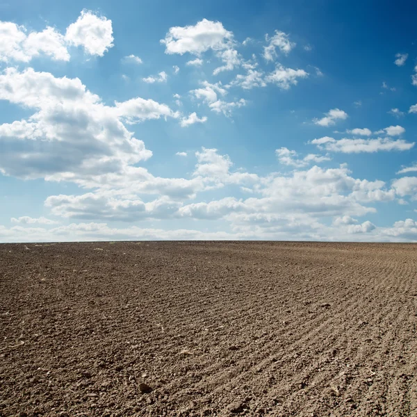 Cloudy sky over ploughed field — Stock Photo, Image