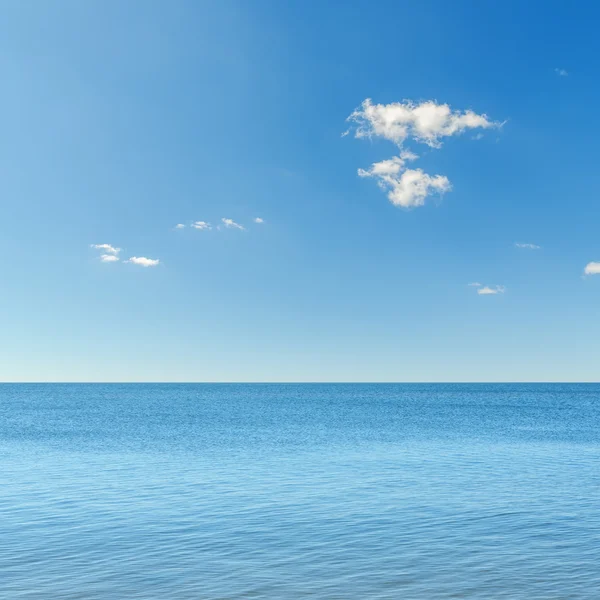 Blauwe hemel met wolken boven zee — Stockfoto