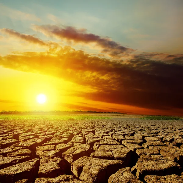 Coucher de soleil spectaculaire sur terre de la sécheresse Photos De Stock Libres De Droits