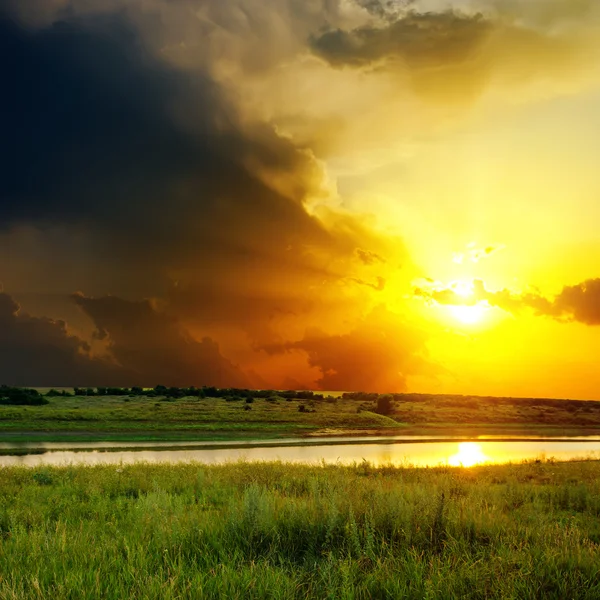 Dramatic orange sunset over river — Stock Photo, Image