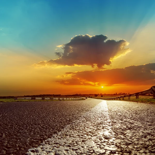 Fantástico pôr do sol sobre estrada de asfalto — Fotografia de Stock