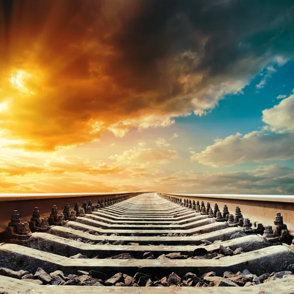 Primer plano del ferrocarril al horizonte bajo el cielo de color en la puesta del sol —  Fotos de Stock