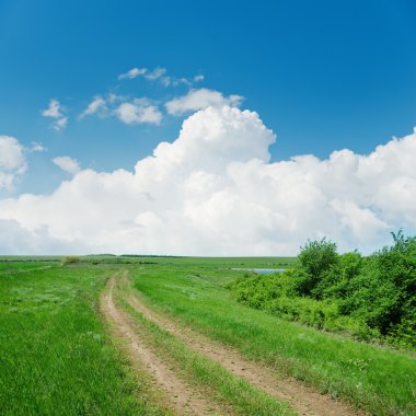 Yeşil manzara ve bulutlarda ele kirli yol