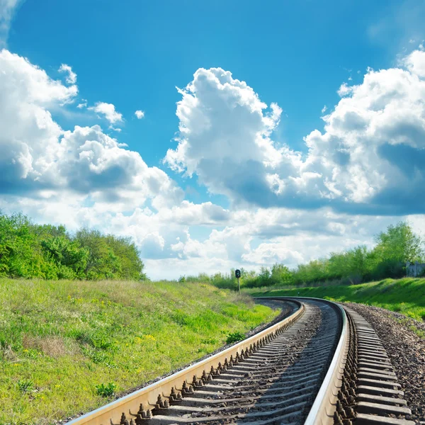 Grönt landskap med järnväg till horisonten och blå himmel med moln — Stockfoto