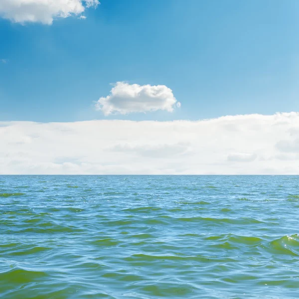 Голубое море, небо и белые облака над ним — стоковое фото