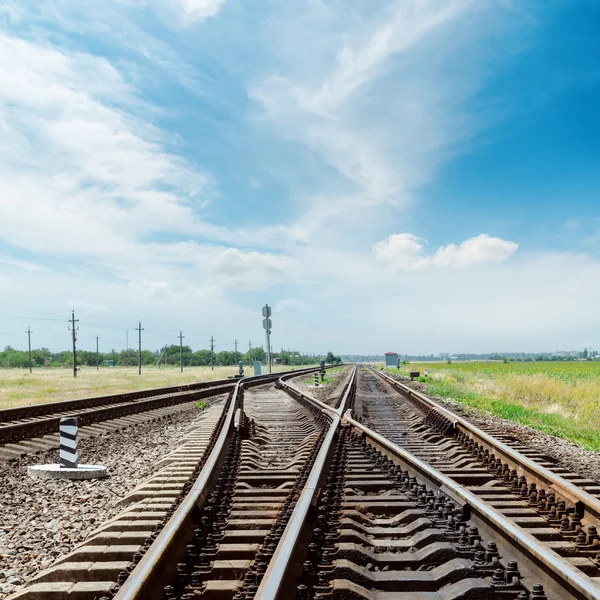 Crossing of railroad under cloudy sky — Stock Photo, Image