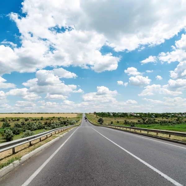 Estrada de asfalto vai para horizonte nublado — Fotografia de Stock
