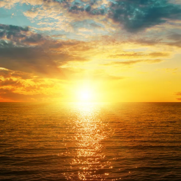 Helder oranje zonsondergang over zee — Stockfoto