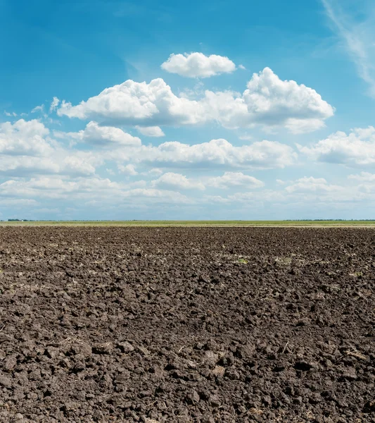 Black arable field after harvesting and blue sky — Stock Photo, Image