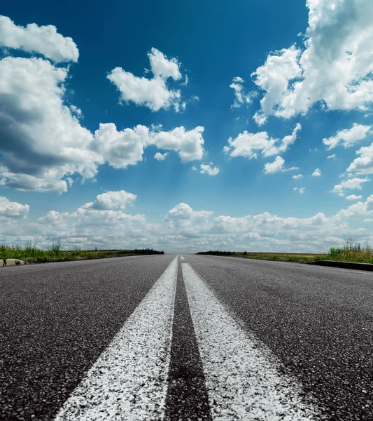 Two white lines on black road and dramatic sky with clouds over — Stock Photo, Image