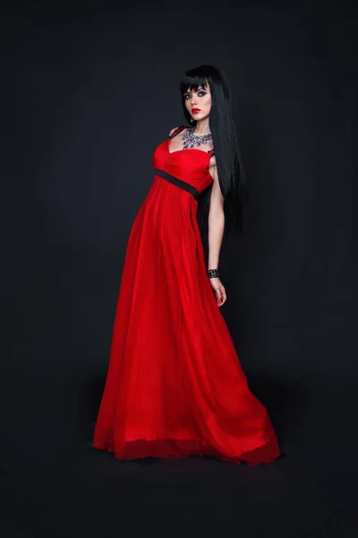 Belle jeune femme en robe longue rouge — Photo