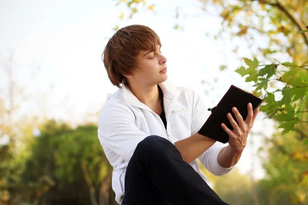Portrait of young man read the book, outdoor autumn Royalty Free Stock Images