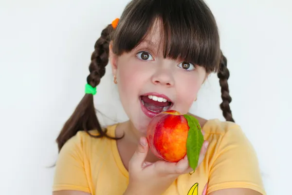 Portret van grappige mooie meisje met perzik — Stockfoto